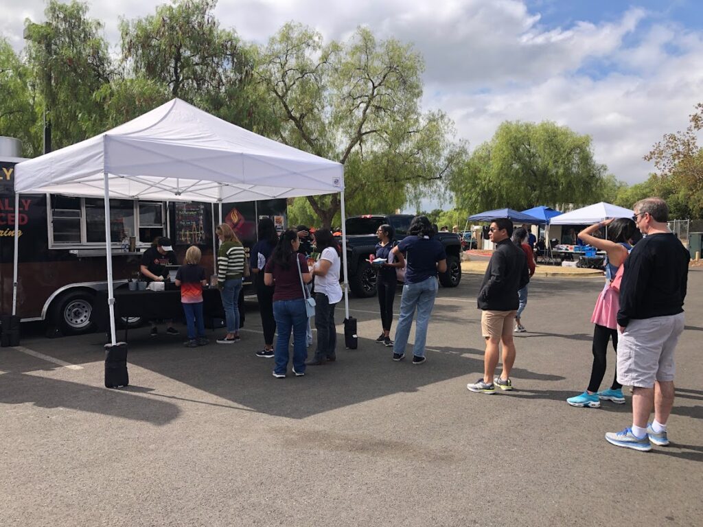 people wait in line for a food truck